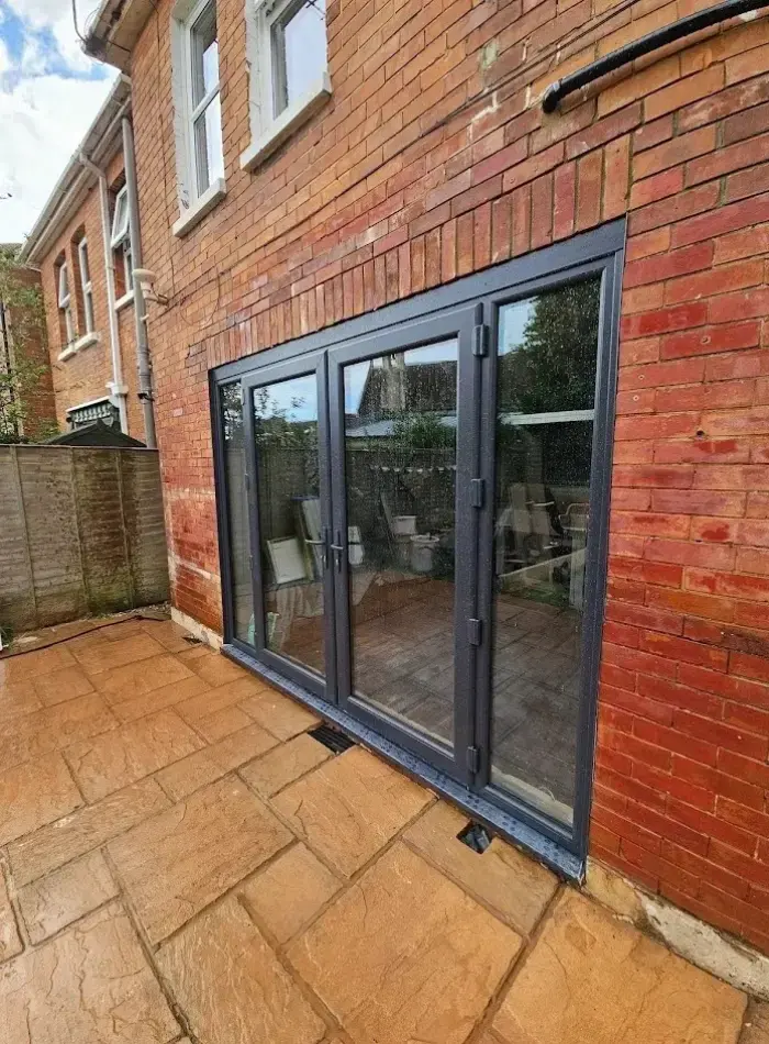 Grey bifold doors opening onto a patio